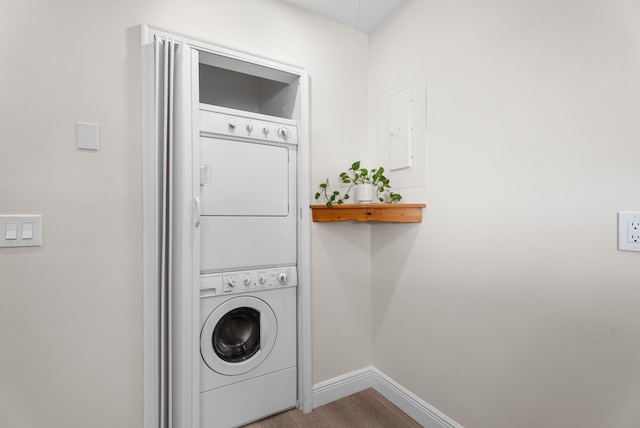 laundry room with stacked washing maching and dryer and light hardwood / wood-style flooring