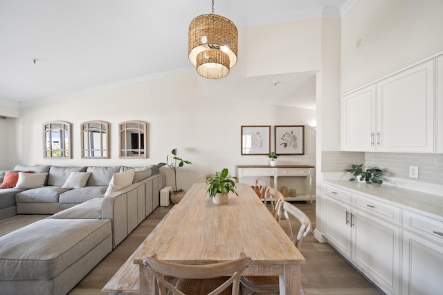 dining area featuring crown molding, a chandelier, dark wood-type flooring, and a high ceiling