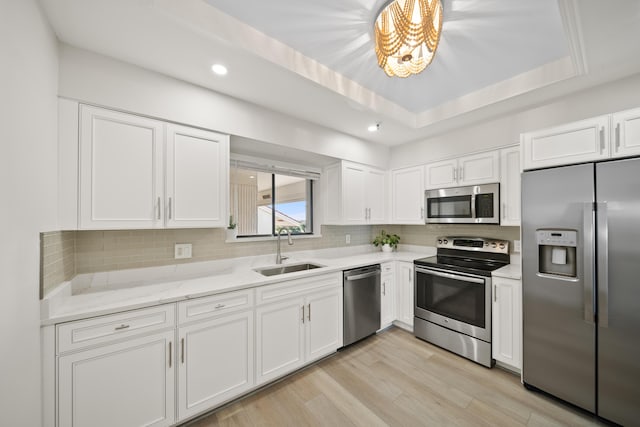 kitchen featuring appliances with stainless steel finishes, sink, and white cabinets