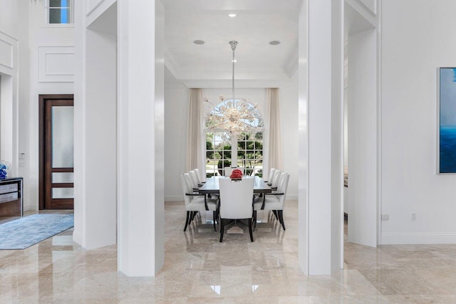 dining space with crown molding and a notable chandelier