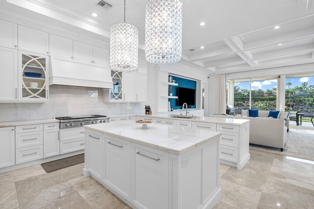 kitchen with a kitchen island, decorative light fixtures, white cabinetry, decorative backsplash, and coffered ceiling