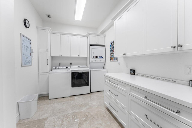 washroom featuring cabinets and separate washer and dryer