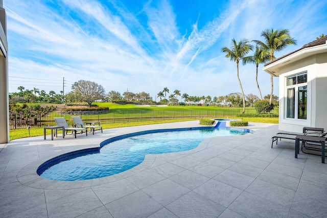 view of pool with a hot tub, a lawn, and a patio area