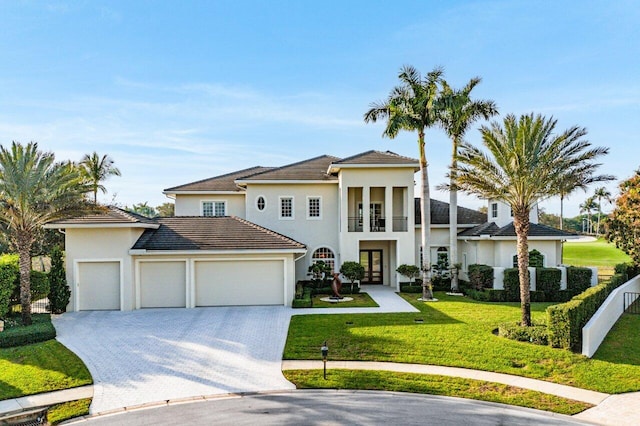 mediterranean / spanish-style house featuring a balcony, a garage, and a front yard