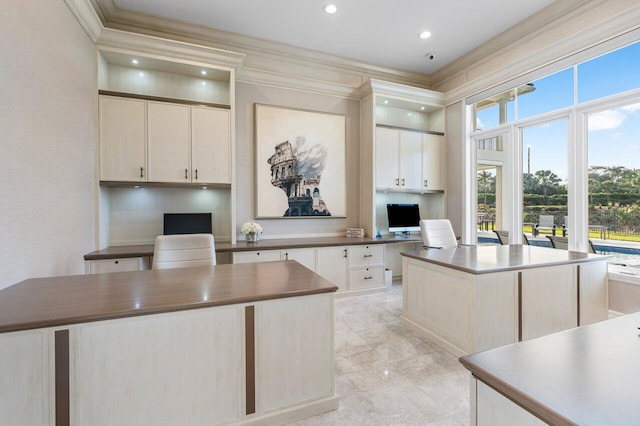 kitchen featuring ornamental molding, a center island, and built in desk