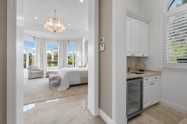 bedroom featuring wine cooler, indoor wet bar, and an inviting chandelier