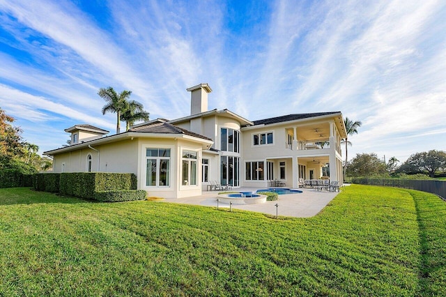 back of property with a patio, a balcony, a swimming pool with hot tub, a yard, and ceiling fan