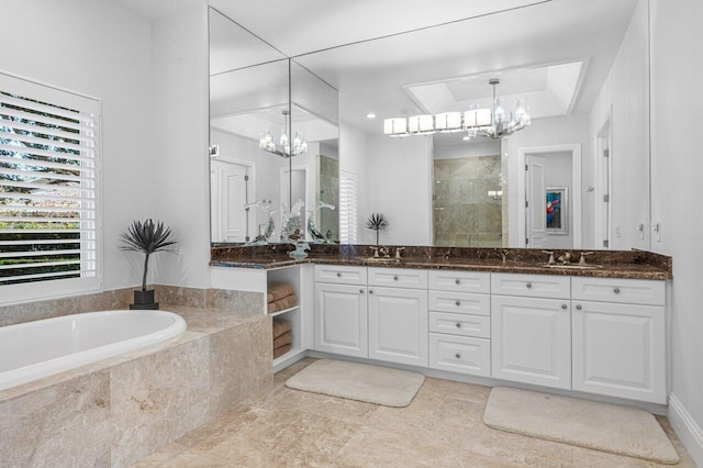 bathroom with an inviting chandelier, vanity, and independent shower and bath