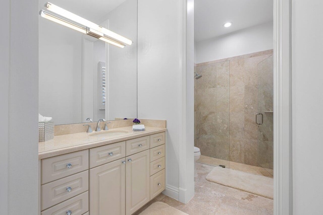 bathroom featuring vanity, toilet, and a shower with door