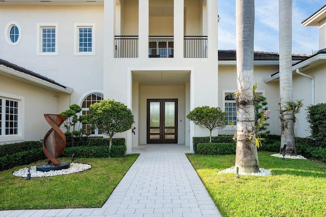 entrance to property featuring french doors and a yard