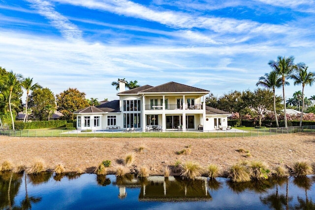 rear view of house with a balcony and a water view