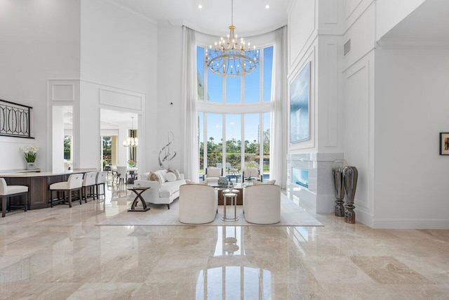 living room featuring a healthy amount of sunlight, crown molding, a premium fireplace, and a chandelier