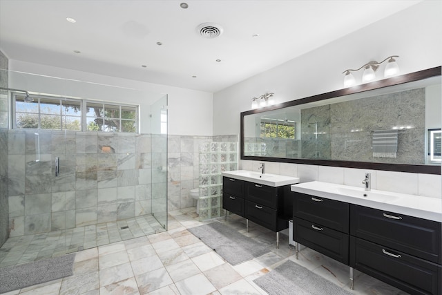 bathroom featuring two vanities, visible vents, a sink, tile walls, and a shower stall