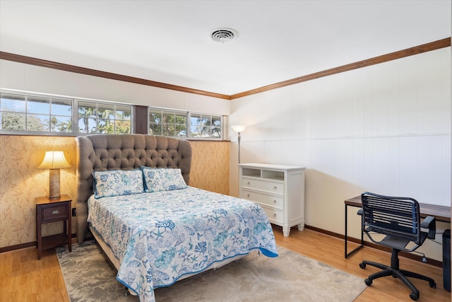 bedroom with wood finished floors, visible vents, and baseboards