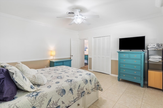 bedroom featuring ornamental molding, a ceiling fan, a closet, and light tile patterned floors