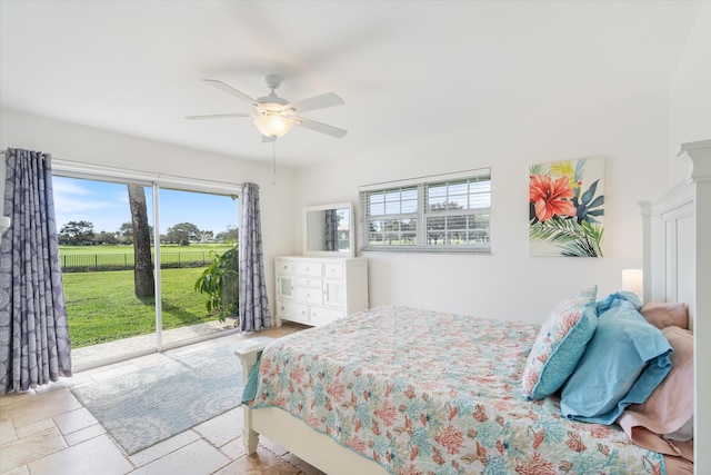 bedroom featuring access to exterior, a ceiling fan, and stone tile flooring