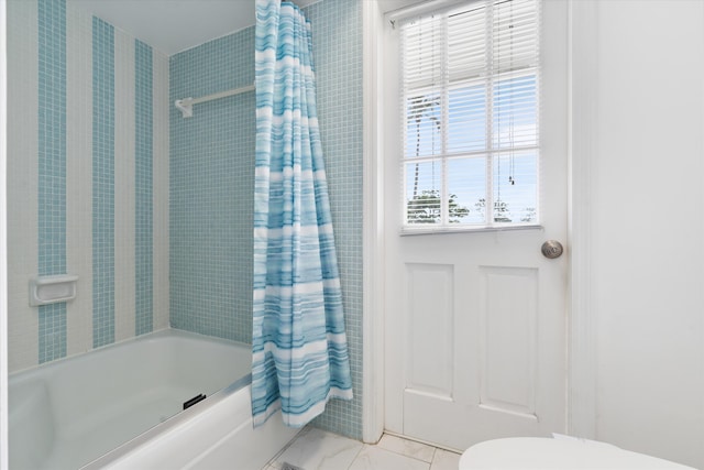 bathroom featuring marble finish floor, shower / bath combination with curtain, and toilet