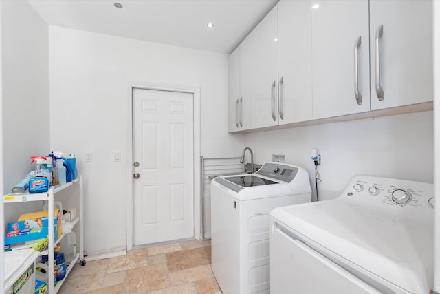 washroom featuring cabinet space, washer and clothes dryer, stone tile flooring, and recessed lighting