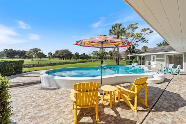 view of swimming pool with a lawn, fence, a fenced in pool, and a patio