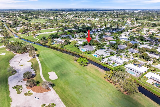 drone / aerial view featuring golf course view, a water view, and a residential view