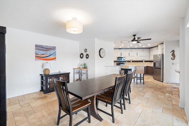 dining area featuring stone tile floors, ceiling fan, and recessed lighting