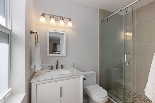 bathroom featuring walk in shower, vanity, and toilet