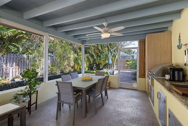 sunroom with beamed ceiling and ceiling fan