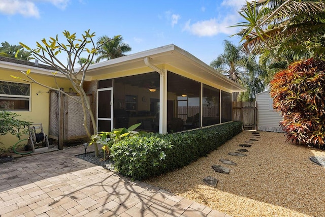 rear view of house featuring a patio area and a sunroom