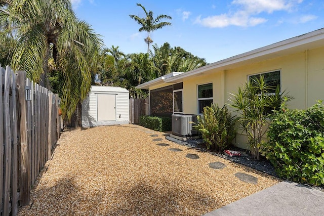 view of yard featuring a storage shed and central air condition unit