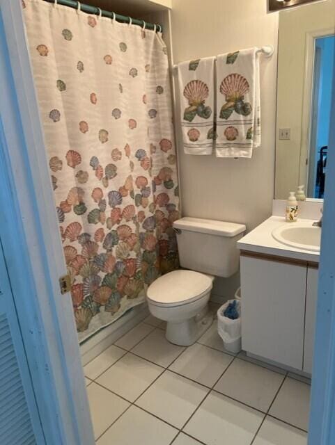 bathroom with toilet, tile patterned flooring, curtained shower, and vanity