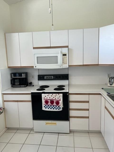 kitchen featuring white cabinetry, white appliances, and light tile patterned flooring