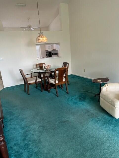 carpeted dining space featuring lofted ceiling and ceiling fan