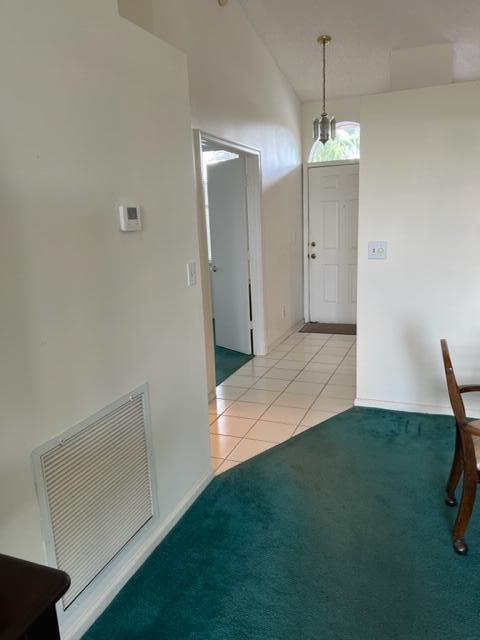 interior space with vaulted ceiling and light tile patterned flooring