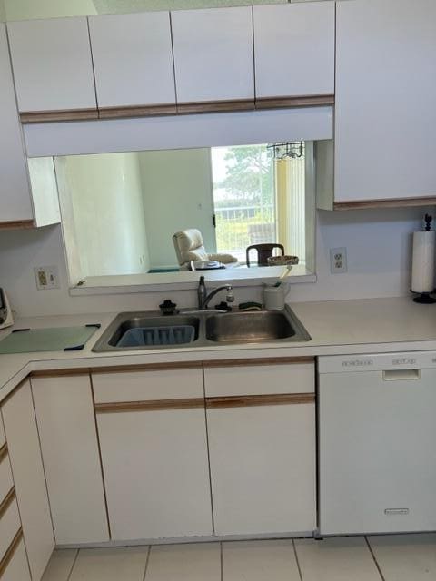 kitchen featuring white cabinetry, light tile patterned floors, sink, and dishwasher