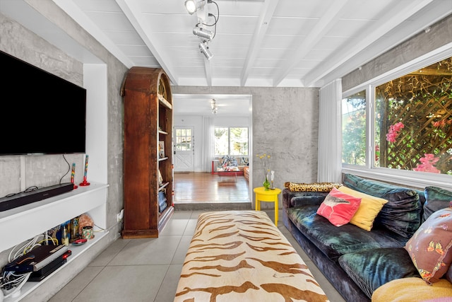 living room featuring beamed ceiling and light tile patterned floors