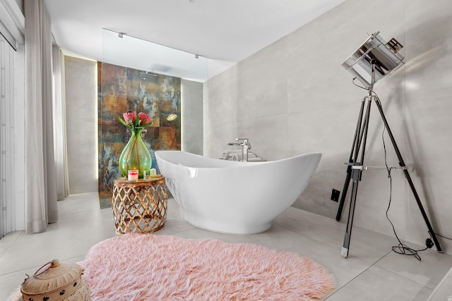 bathroom with tile walls, tile patterned floors, and a bathing tub