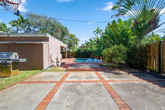 view of patio / terrace featuring a fenced in pool and a grill