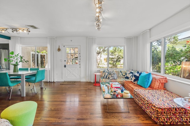 sunroom / solarium featuring a healthy amount of sunlight and rail lighting