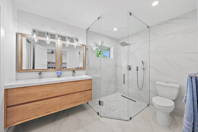 full bathroom featuring toilet, double vanity, a marble finish shower, and a sink