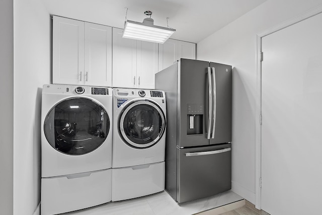 laundry room featuring cabinets and washer and clothes dryer