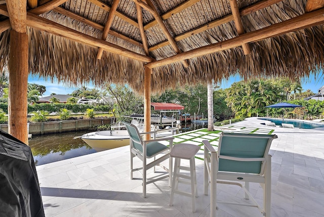 view of patio with a water view, grilling area, a fenced in pool, and a gazebo