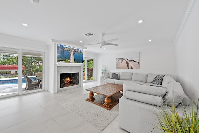 living room with visible vents, recessed lighting, ornamental molding, ceiling fan, and a lit fireplace