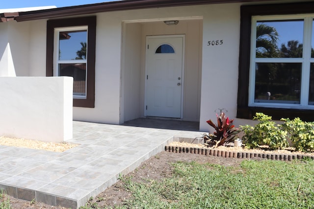 doorway to property featuring stucco siding