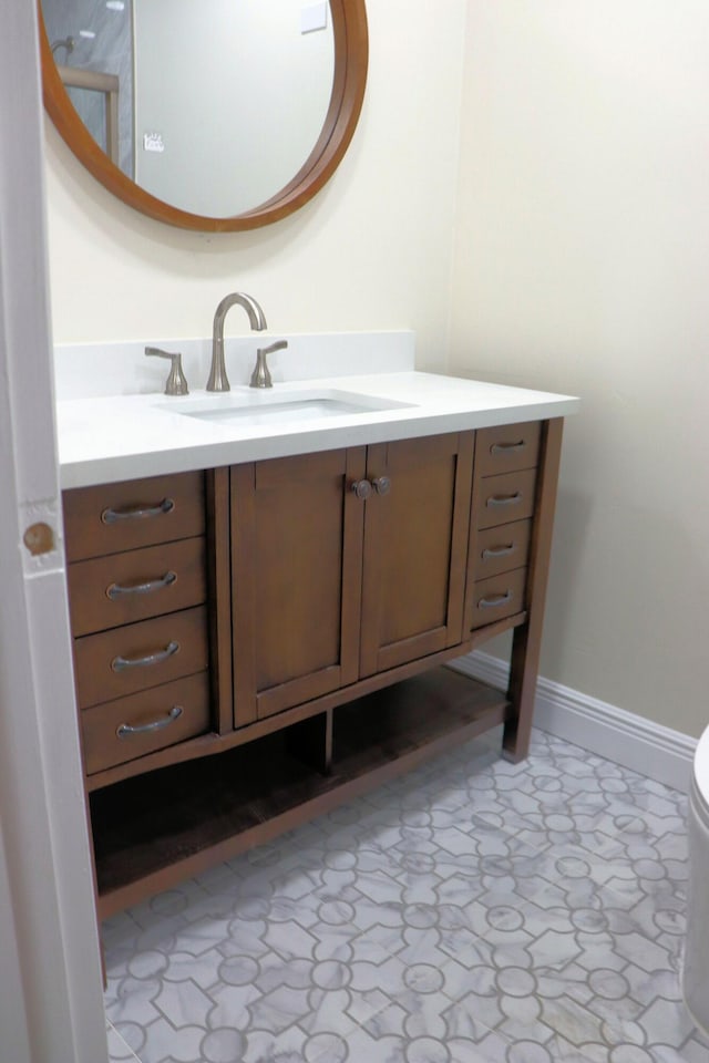bathroom featuring vanity, baseboards, and toilet