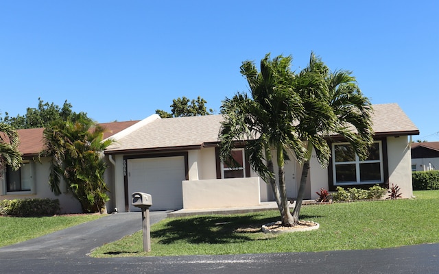 ranch-style home featuring aphalt driveway, stucco siding, an attached garage, and a front lawn