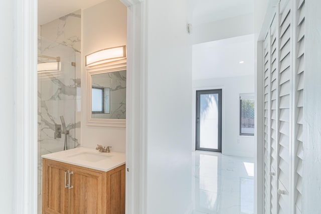 bathroom with vanity and a tile shower