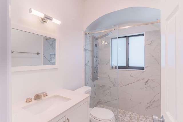 bathroom featuring vanity, an enclosed shower, and toilet