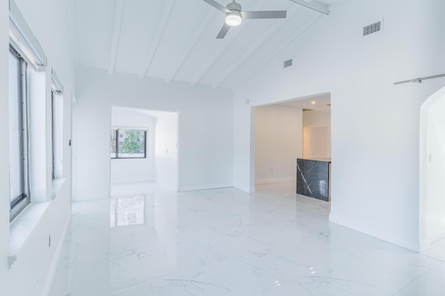 empty room with ceiling fan, high vaulted ceiling, and beam ceiling