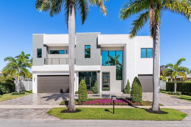 contemporary house featuring a garage and a balcony