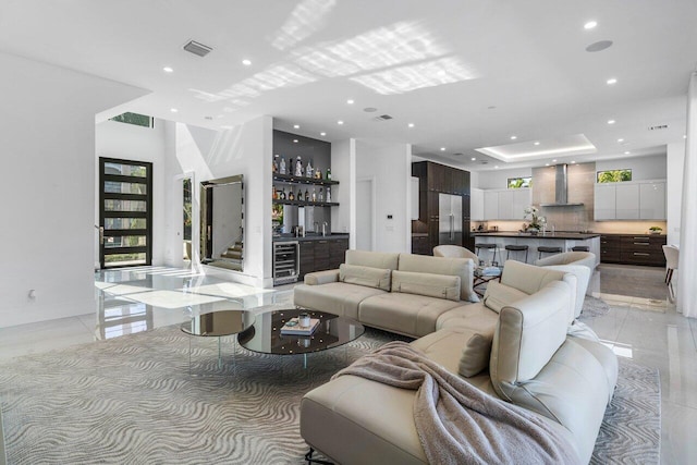 living room with wine cooler, visible vents, recessed lighting, and a bar